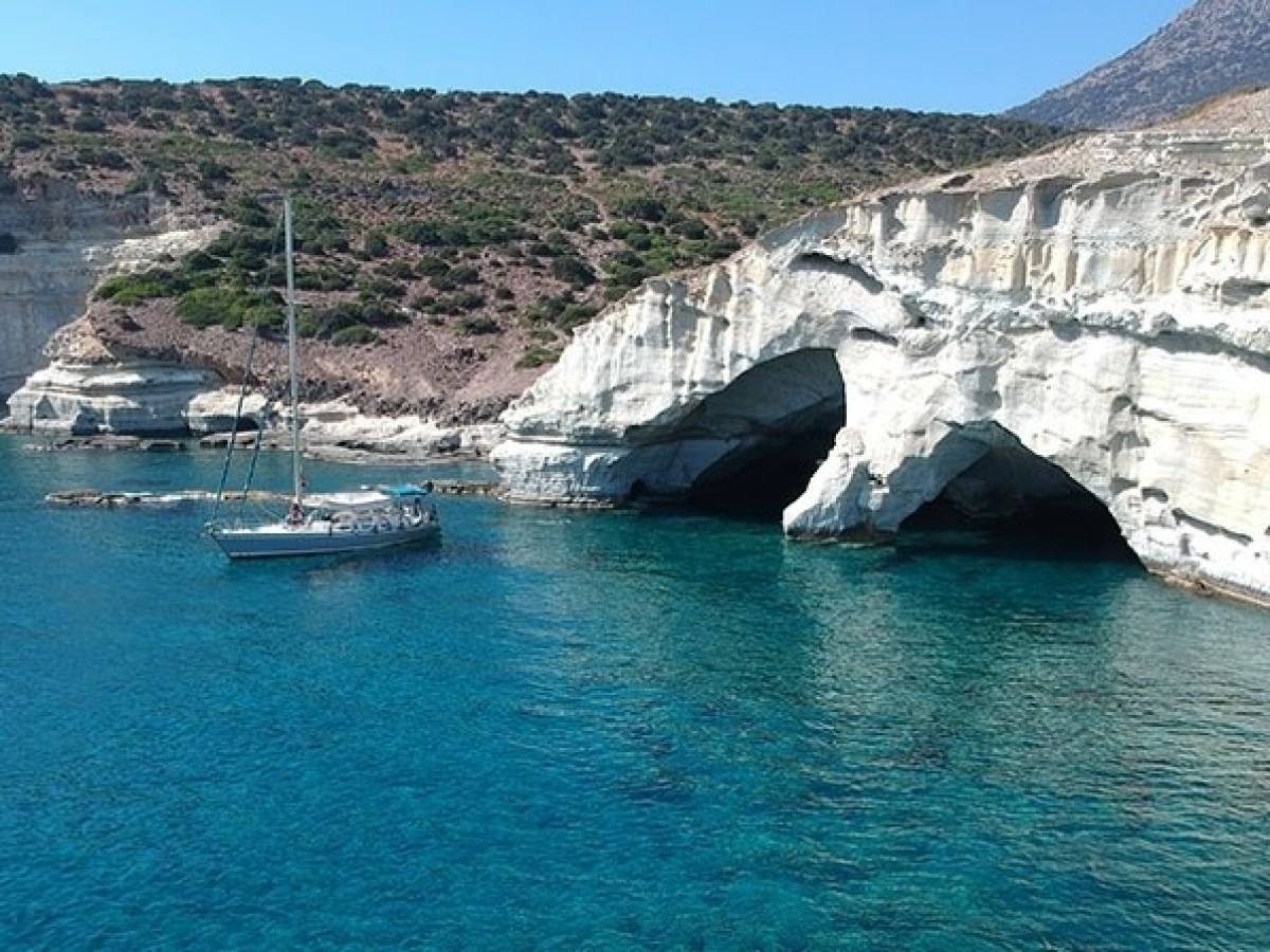 a small boat in a body of water with a mountain in the background